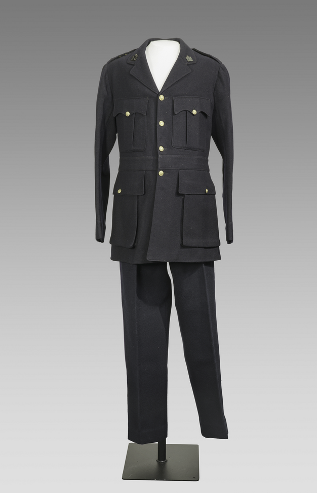 Modern photograph of a navy-blue wool tunic decorated with gold buttons and other metal insignias, displayed on a mannequin along with navy-blue wool pants.