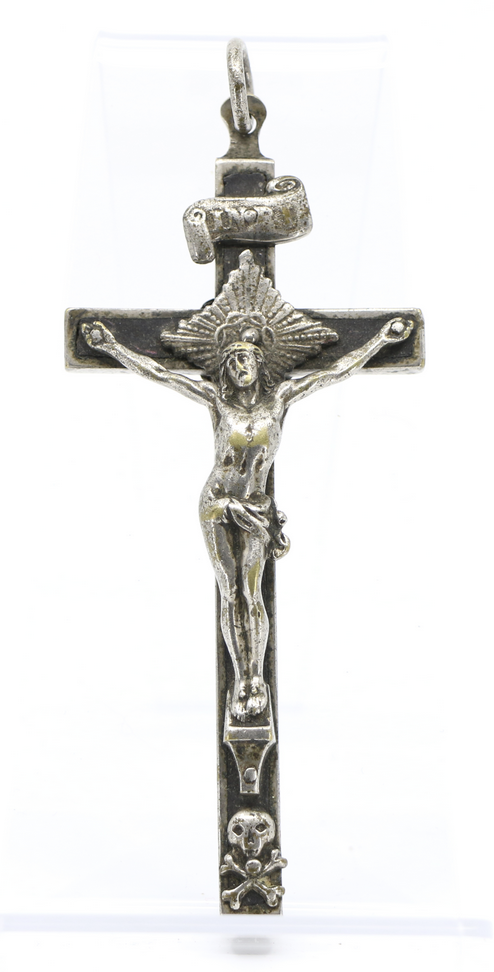 Modern photograph of a silver crucifix pendant that includes depictions of a scroll and a skull and crossbones.